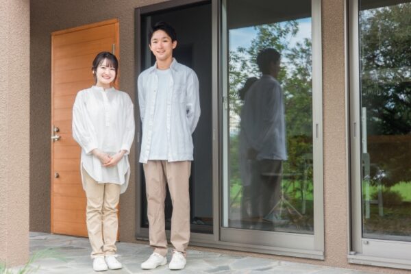 家の前に立つ夫婦
