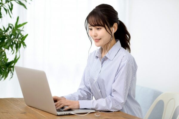 イヤホンをしてPC作業をする女性